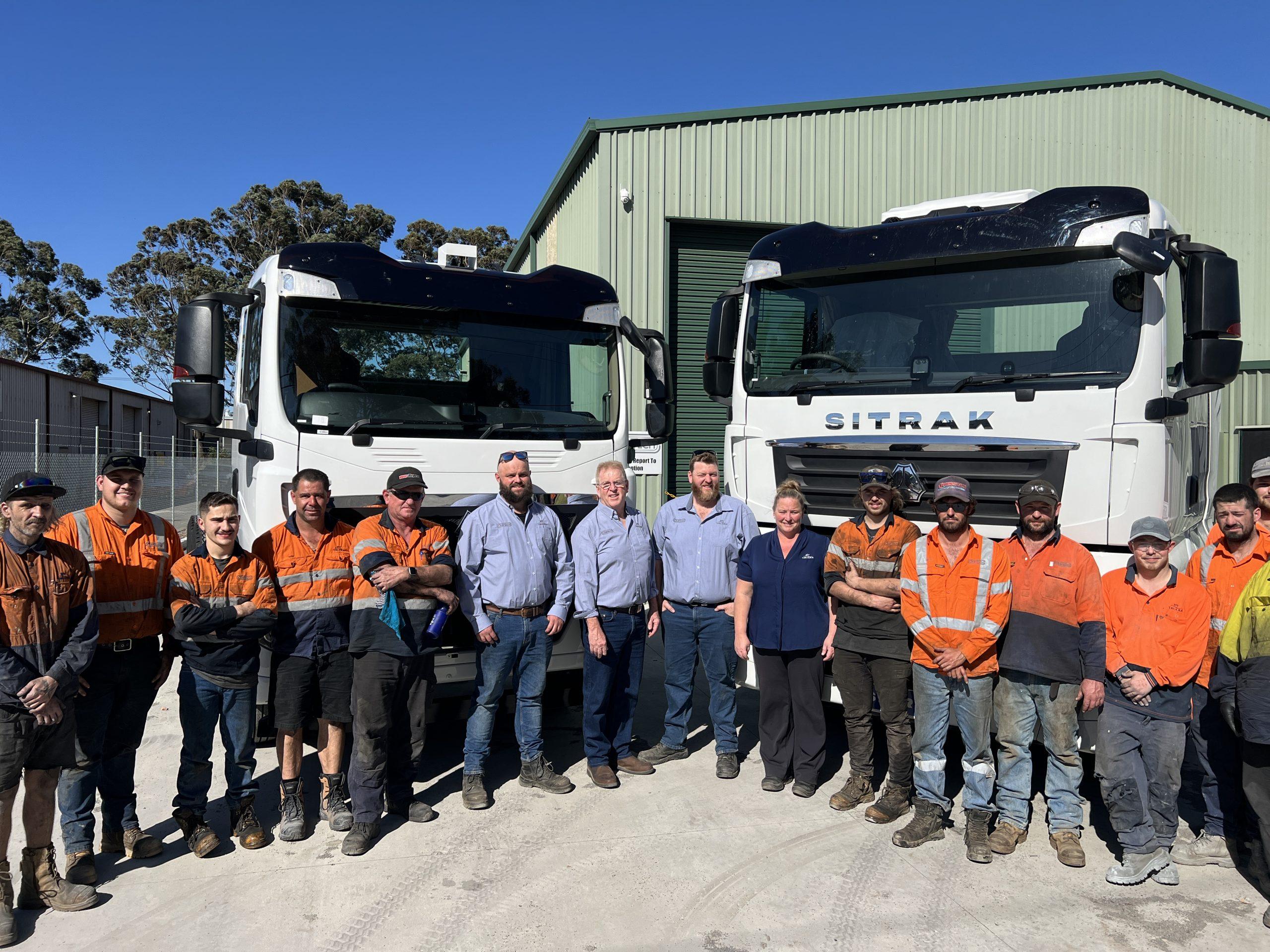 The Sitrak Trucks Newcastle team in front of two Sitrak trucks